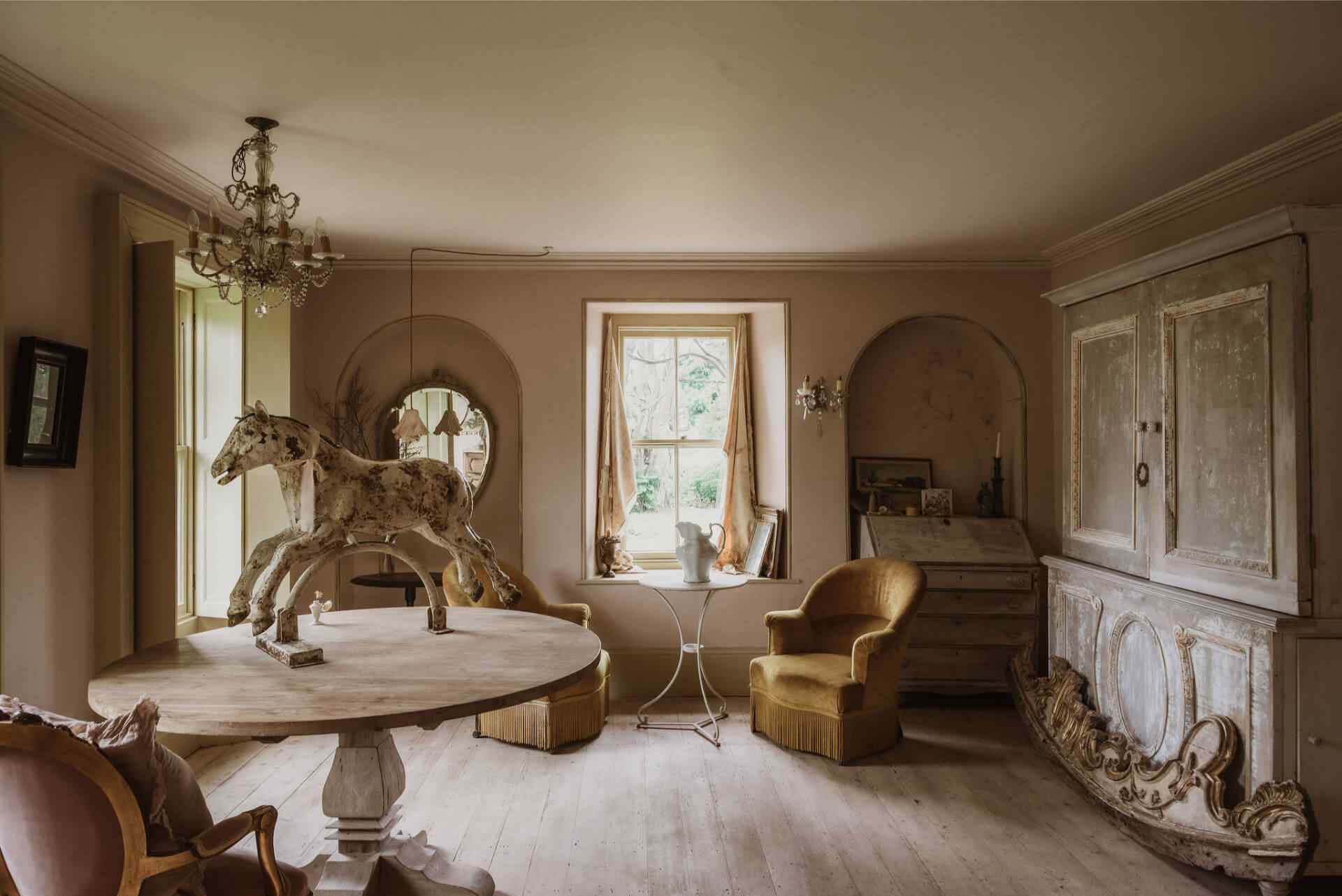 A beauitfully decorated Georgian living room with antiques and warm soft pink and yellow hues