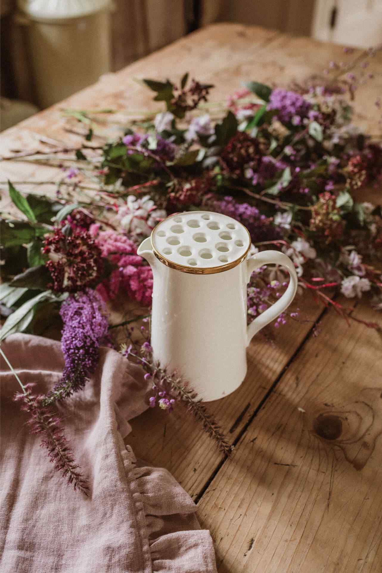 A white bone china jug with a white and gold Halliesphere flower arranger