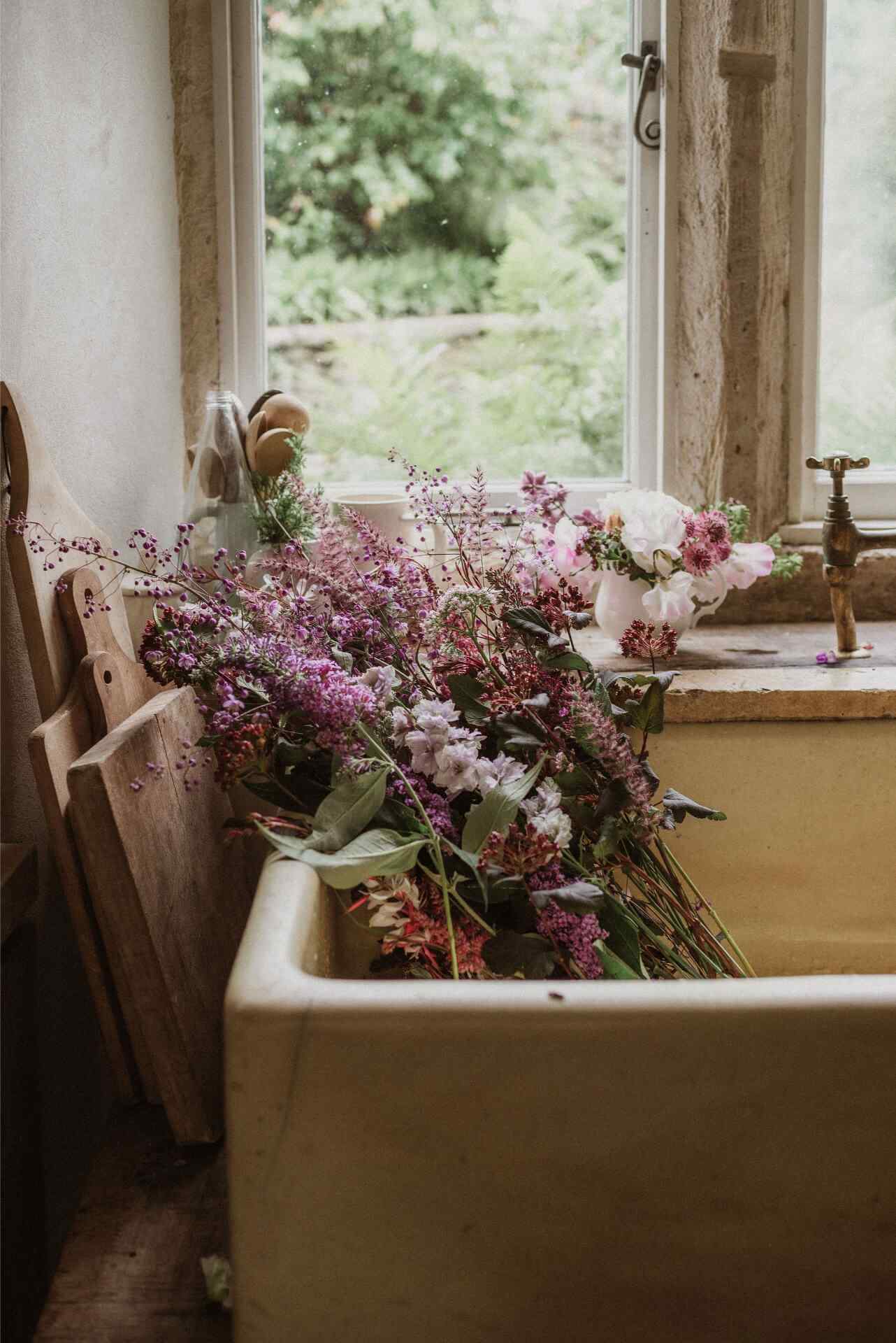 An antique cream butler sink filled with freshly cut flowers from the garden