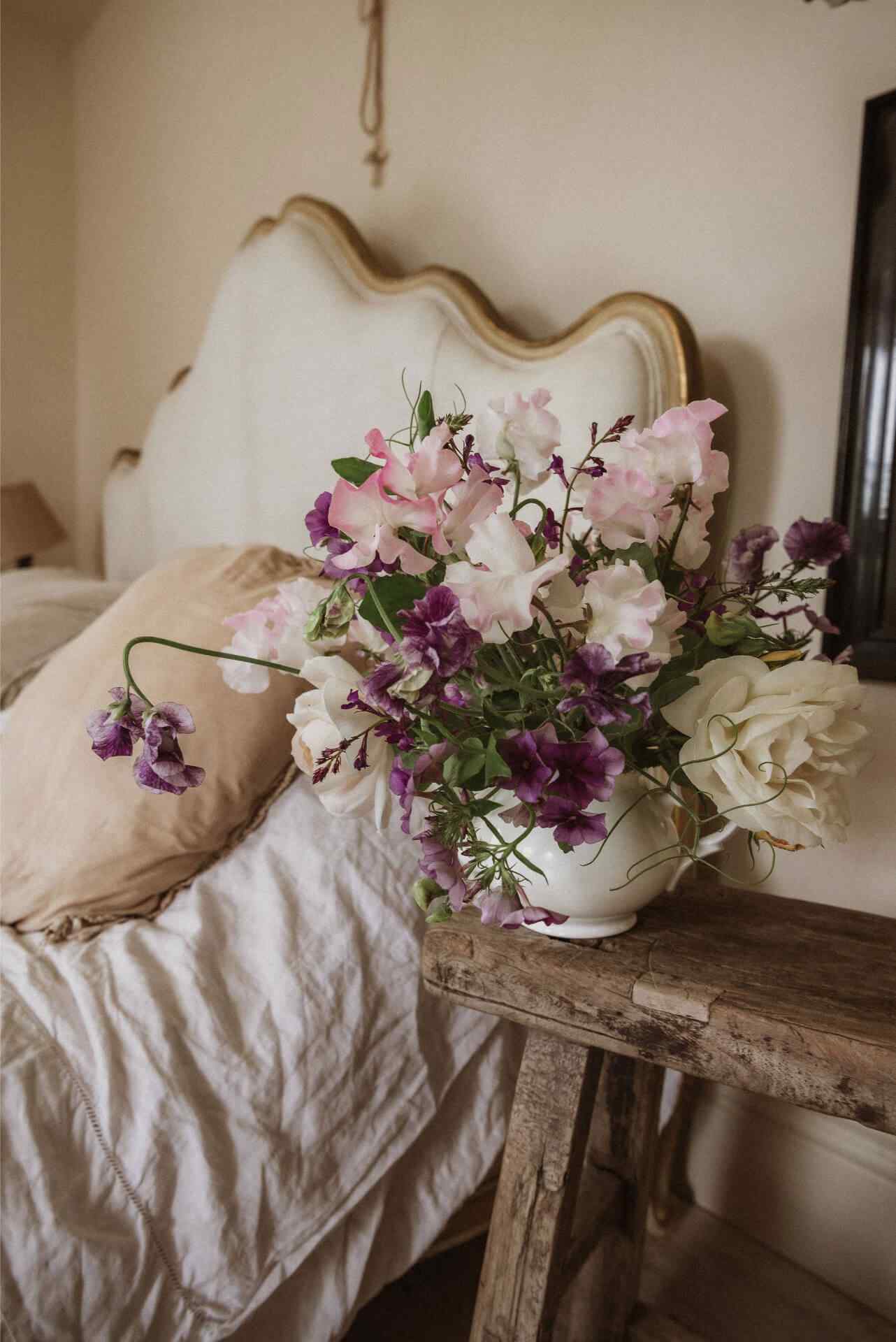 Sweet pea flowers arranged next to a French style bed